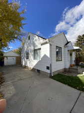 View of property exterior featuring a garage, an outbuilding, and concrete driveway