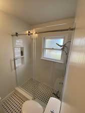 Bathroom with a shower stall and tile patterned flooring