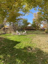 View of grassy yard featuring a patio and a fire pit