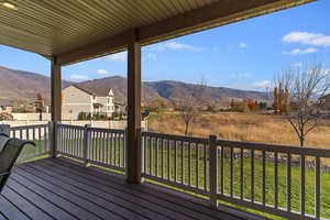 Wooden deck featuring a mountain view, a residential view, and a lawn