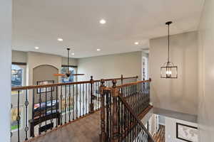 Hall with recessed lighting, an upstairs landing, and carpet