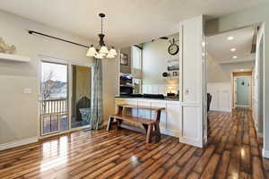 Dining area featuring dark wood-style floors and a chandelier
