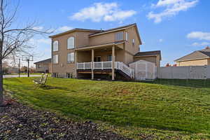 Rear view of property with stucco siding and a wooden deck