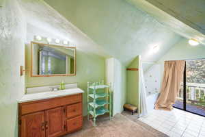 Full bathroom featuring vaulted ceiling, light carpet, vanity, a textured ceiling, and light tile patterned flooring