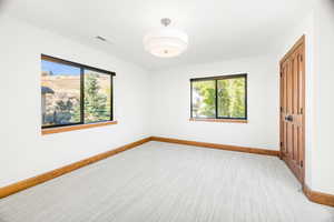 Carpeted empty room featuring healthy amount of natural light
