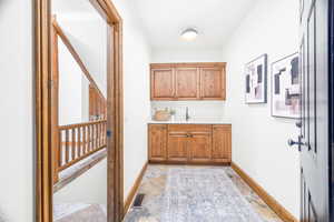 Bar area featuring light countertops, brown cabinets, and light stone finish flooring