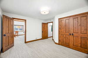 Unfurnished bedroom featuring light colored carpet