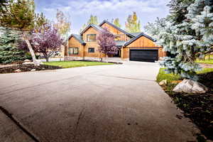 View of front of house with driveway, a garage, and a front yard