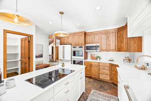 Kitchen with white appliances, recessed lighting, white cabinets, hanging light fixtures, and light stone countertops