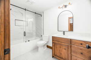 Full bathroom featuring vanity, shower / bath combination with glass door, and light tile patterned floors