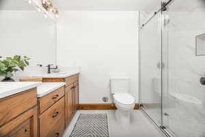 Full bathroom with vanity, light tile patterned floors, and a marble finish shower