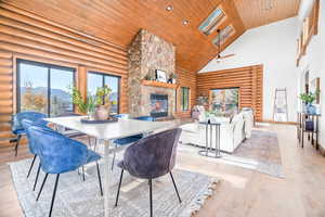 Dining space with high vaulted ceiling, a fireplace, wooden ceiling, wood finished floors, and a mountain view