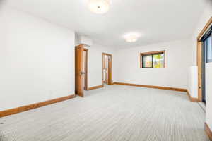 Empty room featuring baseboards and light colored carpet