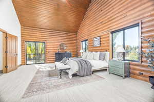 Bedroom with high vaulted ceiling, log walls, carpet, access to exterior, and wooden ceiling