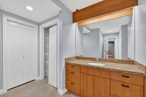 Full bathroom featuring light tile patterned flooring, vanity, a walk in closet, and recessed lighting