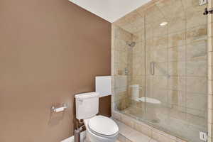 Full bathroom with a stall shower and tile patterned flooring