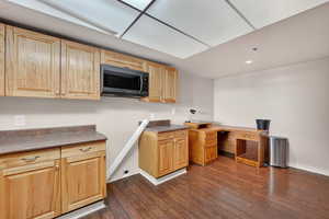 Kitchen featuring black microwave, dark wood-style floors, recessed lighting, and light brown cabinets