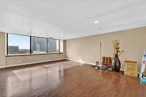 Unfurnished room with wood finished floors, recessed lighting, and a view of city