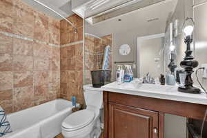Full bath with shower / tub combo with curtain and vanity