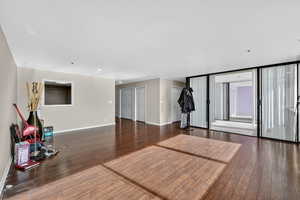 Unfurnished living room featuring dark wood finished floors and floor to ceiling windows