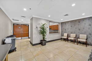 Building lobby with wallpapered walls, ornamental molding, and recessed lighting