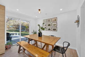 Dining area with light wood-style floors and recessed lighting