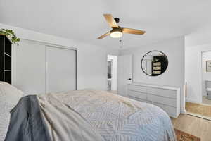 Bedroom featuring wood finished floors, a closet, and a ceiling fan