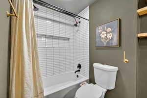 Bathroom with shower / tub combo and toilet