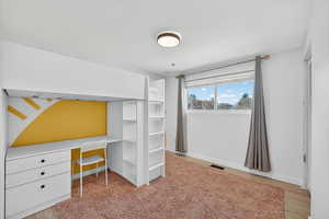 Unfurnished bedroom featuring built in desk, light wood-style floors, and a closet
