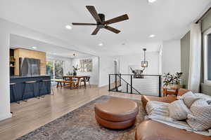 Living room featuring recessed lighting, light wood-type flooring, and a ceiling fan