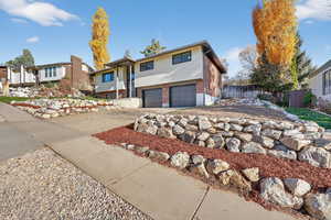 Bi-level home with brick siding, concrete driveway, and a garage