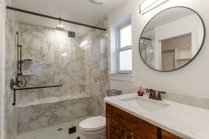 Bathroom with vanity and a marble finish shower
