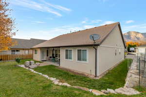 Back of house featuring a fenced backyard, a shingled roof, a patio, and stucco siding