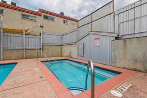 Community pool with a jacuzzi and a patio area