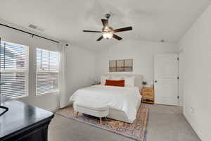 Bedroom featuring lofted ceiling, light colored carpet, and ceiling fan