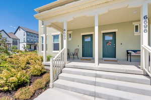 View of exterior entry with a porch and stucco siding