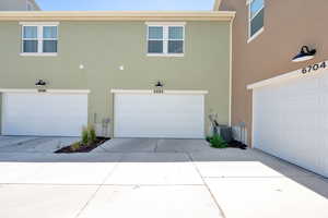 View of property exterior featuring a garage, stucco siding, and driveway