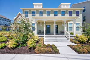 Colonial home with a porch and stucco siding
