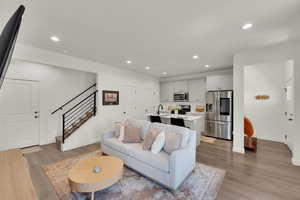 Living room featuring recessed lighting, stairs, and light wood finished floors