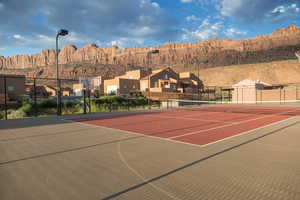 View of tennis court with community basketball court, a mountain view, and a residential view