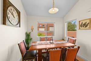 Dining space with vaulted ceiling and tile patterned floors