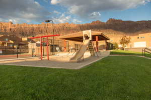 Community jungle gym with a mountain view and a patio area