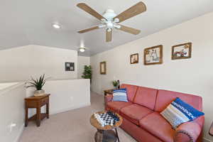 Living room featuring carpet floors and a ceiling fan