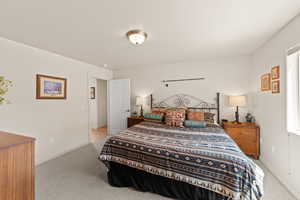 Bedroom with light colored carpet and baseboards