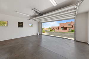Garage featuring a garage door opener and a residential view