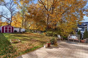 Wooden terrace featuring a fenced backyard and a storage shed