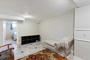 Living area with light tile patterned floors and a textured ceiling