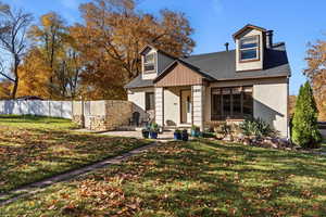 View of front of property with a shingled roof, stucco siding, and a patio area