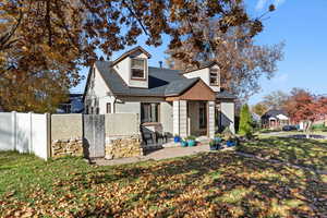 Rear view of property featuring a porch, roof with shingles, and stucco siding