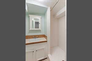 Bathroom featuring vanity, a shower stall, and light tile patterned floors
